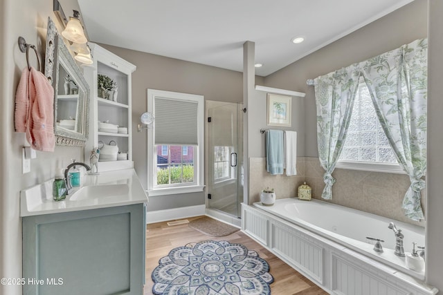 bathroom with wood finished floors, a sink, a shower stall, and a bath