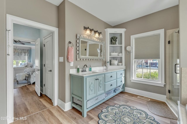 full bath with a healthy amount of sunlight, a stall shower, and wood finished floors