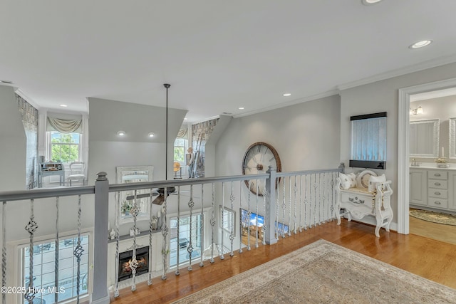 hall featuring crown molding, wood finished floors, and recessed lighting