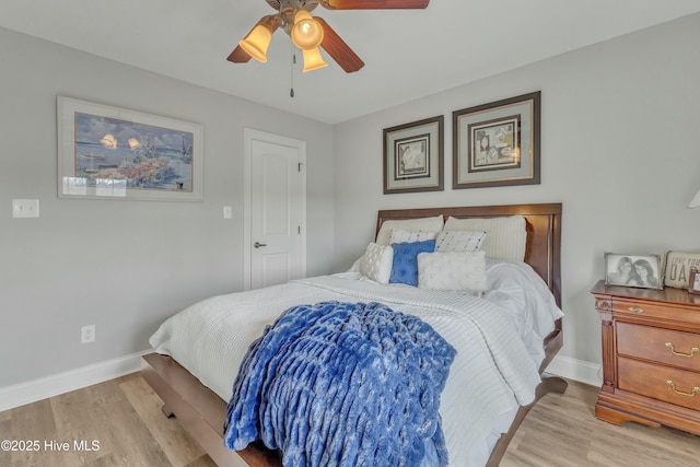 bedroom with a ceiling fan, baseboards, and wood finished floors