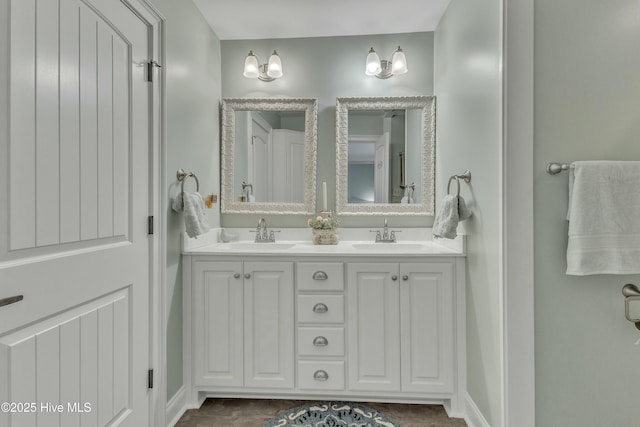 bathroom featuring double vanity, baseboards, and a sink