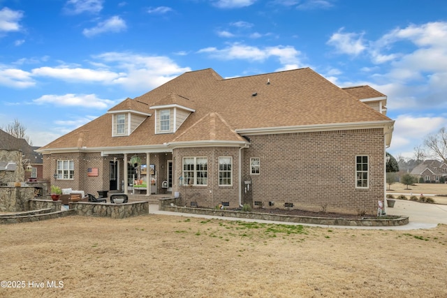 rear view of property with a patio area, a shingled roof, and brick siding