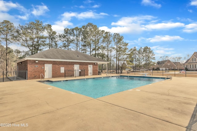 community pool with a patio and fence