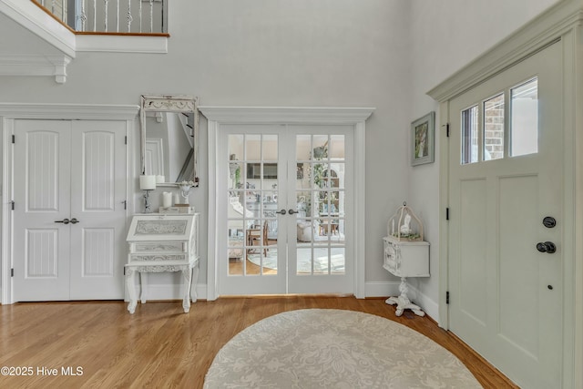 foyer entrance featuring french doors, baseboards, and wood finished floors