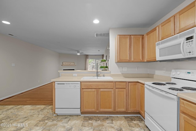 kitchen with white appliances, visible vents, a peninsula, light countertops, and a sink