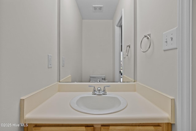 bathroom featuring visible vents, vanity, and toilet