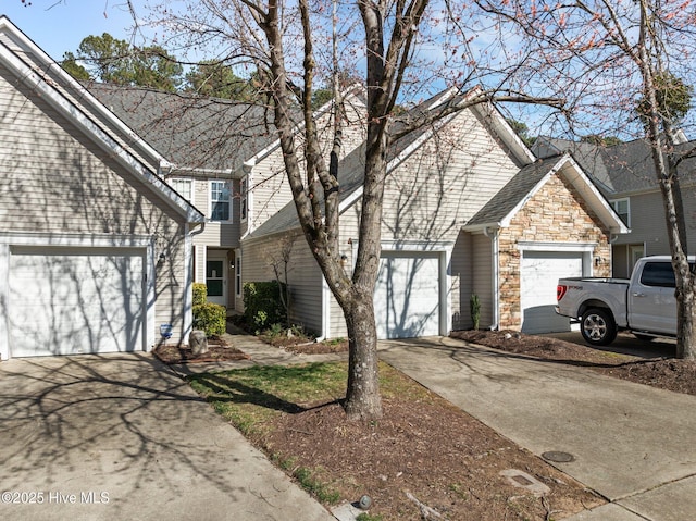 view of front facade featuring stone siding, roof with shingles, driveway, and an attached garage