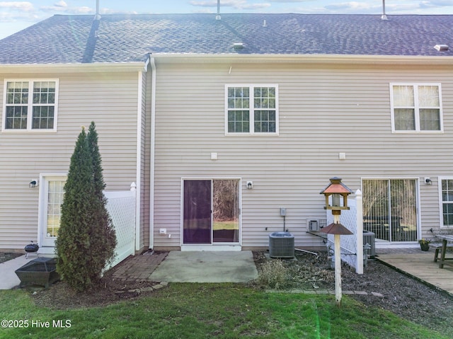 rear view of property with a patio, central AC unit, and roof with shingles