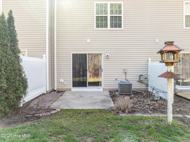 rear view of property featuring a patio area, fence, and central AC unit