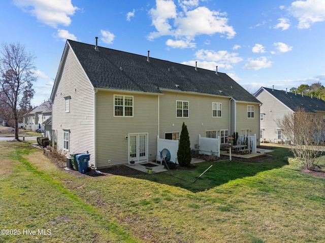 back of property featuring a shingled roof, french doors, and a lawn