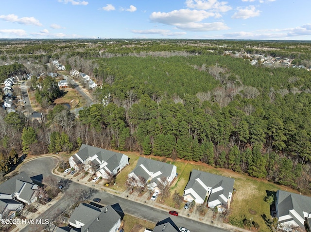 drone / aerial view featuring a residential view and a wooded view