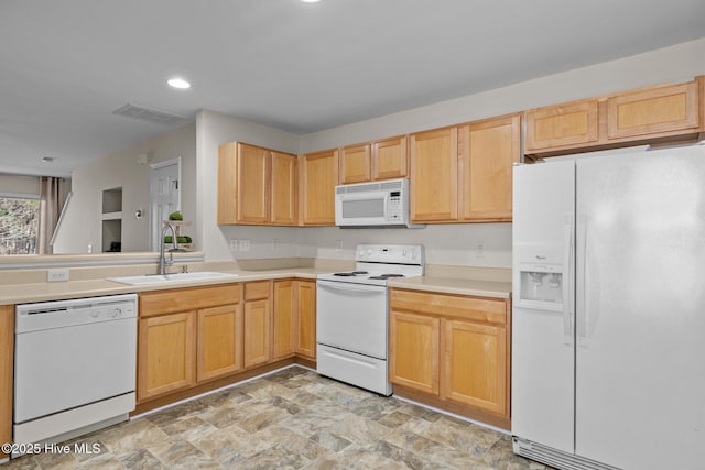 kitchen with white appliances, a sink, visible vents, light countertops, and stone finish floor