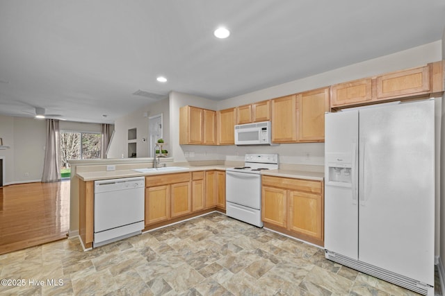 kitchen with light countertops, open floor plan, a sink, white appliances, and a peninsula