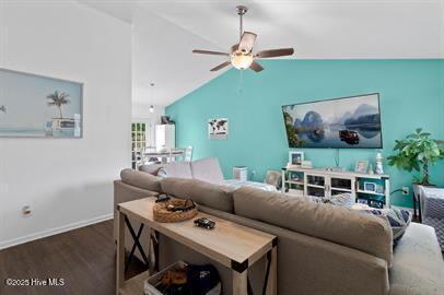 living area featuring vaulted ceiling, wood finished floors, a ceiling fan, and baseboards