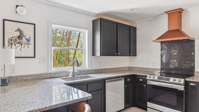 kitchen featuring appliances with stainless steel finishes, ornamental molding, a sink, wall chimney range hood, and dark cabinetry