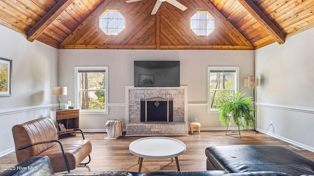 living room featuring beamed ceiling, a fireplace, wood-type flooring, and wood ceiling