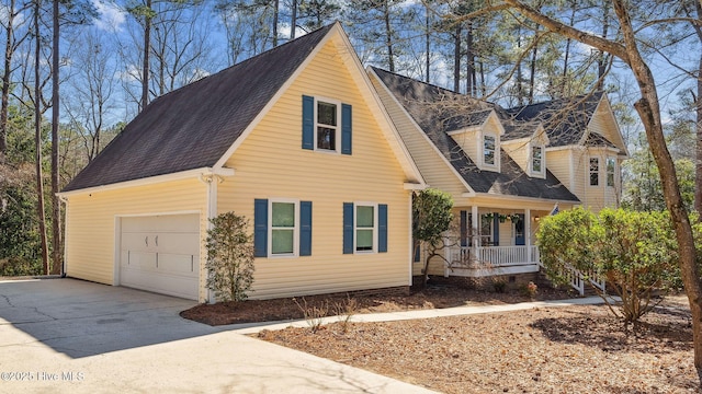 view of front of property featuring an attached garage, covered porch, a shingled roof, and concrete driveway