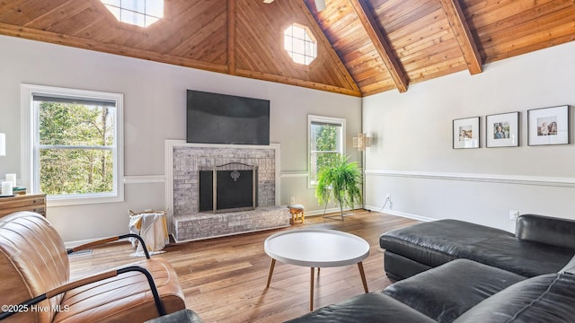 living area with wood ceiling, a brick fireplace, plenty of natural light, and wood-type flooring