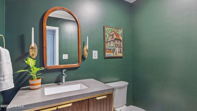 half bathroom featuring vanity and toilet