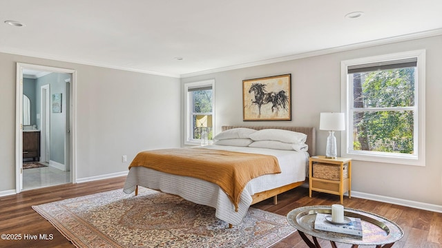 bedroom featuring baseboards, ensuite bathroom, wood finished floors, and crown molding