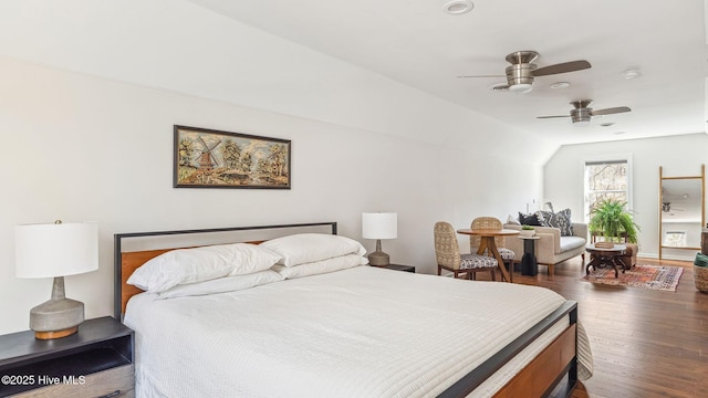 bedroom with a ceiling fan, vaulted ceiling, and wood finished floors