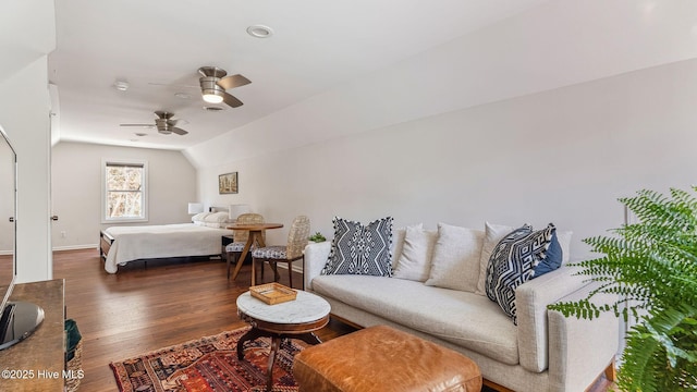 bedroom featuring lofted ceiling, baseboards, a ceiling fan, and wood finished floors
