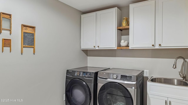 clothes washing area with washing machine and dryer, cabinet space, and a sink