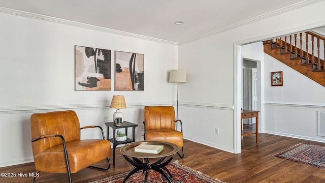 living area with baseboards, wood finished floors, stairs, and crown molding