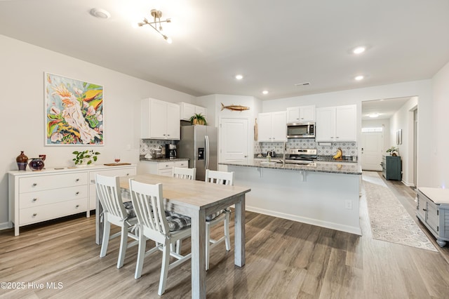 kitchen with light wood-style flooring, white cabinetry, and stainless steel appliances