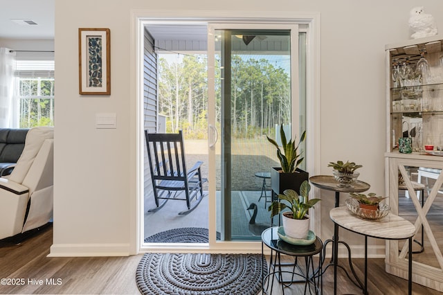 doorway with baseboards and wood finished floors