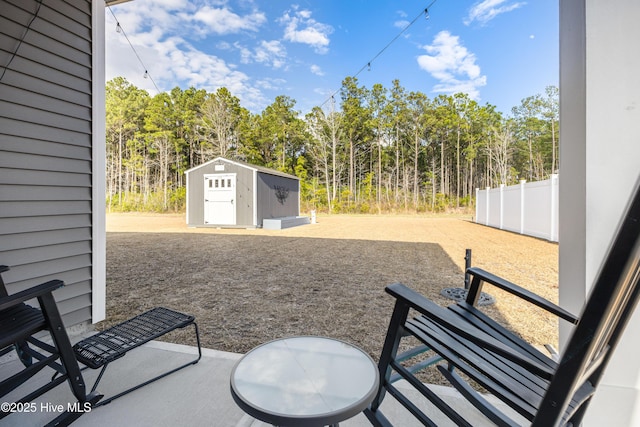 view of patio / terrace featuring a shed, an outdoor structure, and fence