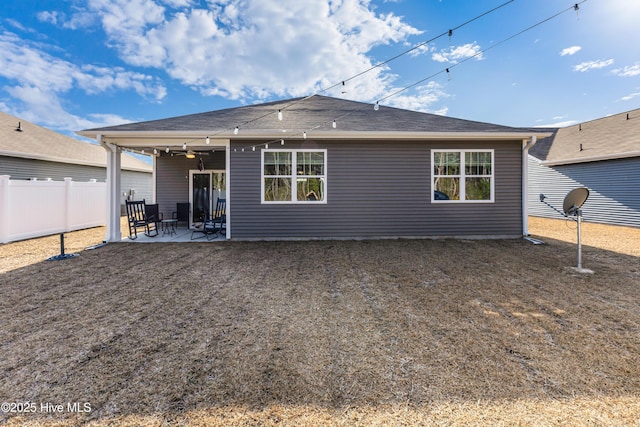 rear view of house with a patio and fence