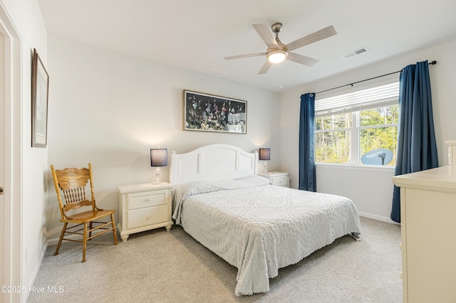 bedroom with baseboards, ceiling fan, visible vents, and light colored carpet