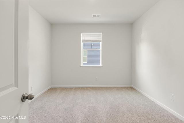 spare room featuring carpet flooring, visible vents, and baseboards