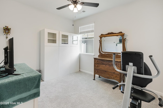 home office featuring baseboards, carpet floors, visible vents, and a ceiling fan