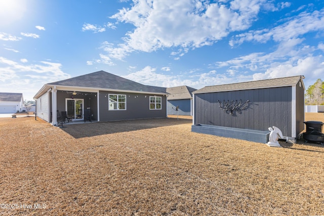 rear view of house with a patio, an outdoor structure, and a ceiling fan