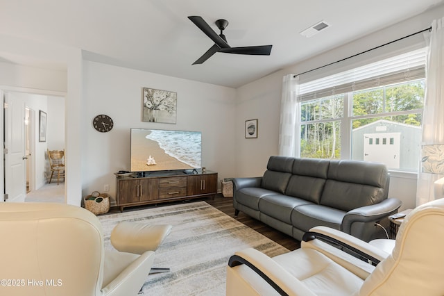 living area with wood finished floors, visible vents, and a ceiling fan