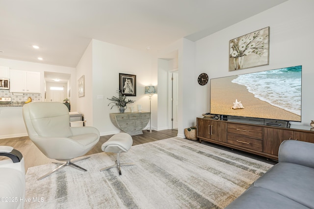 living room with baseboards, wood finished floors, and recessed lighting