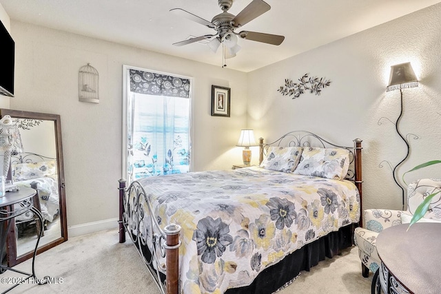 carpeted bedroom with ceiling fan and baseboards