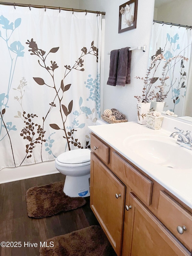 full bathroom featuring toilet, wood finished floors, vanity, and a shower with curtain