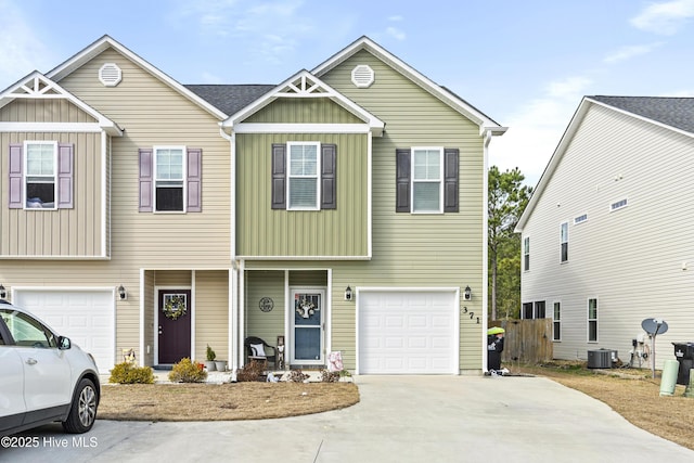 view of front facade with board and batten siding, concrete driveway, central AC, and an attached garage