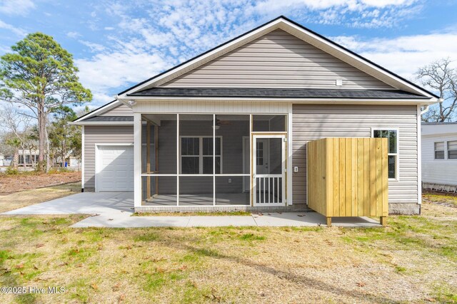 147 NE 18th St, Oak Island, NC 28465 - rear view of house featuring a sunroom, an attached garage, and a shingled roof