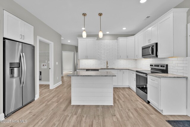 147 NE 18th St, Oak Island, NC 28465 - kitchen with appliances with stainless steel finishes, a sink, decorative backsplash, white cabinetry, and recessed lighting