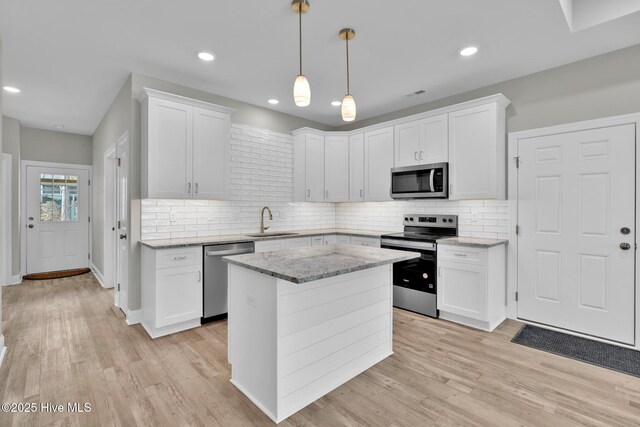 147 NE 18th St, Oak Island, NC 28465 - kitchen featuring appliances with stainless steel finishes, a sink, white cabinetry, backsplash, and recessed lighting