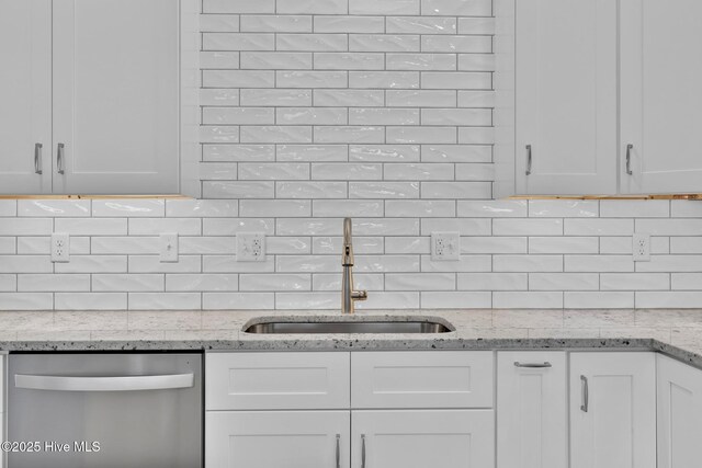 147 NE 18th St, Oak Island, NC 28465 - kitchen with stainless steel dishwasher, a sink, and white cabinetry