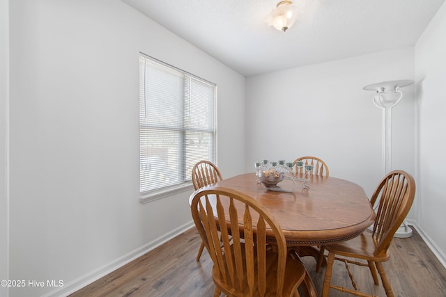 dining space with light wood-type flooring and baseboards