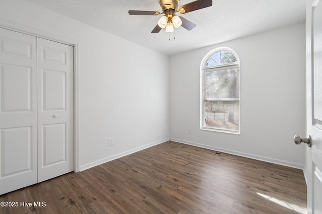 unfurnished bedroom featuring a ceiling fan, wood finished floors, baseboards, and a textured ceiling