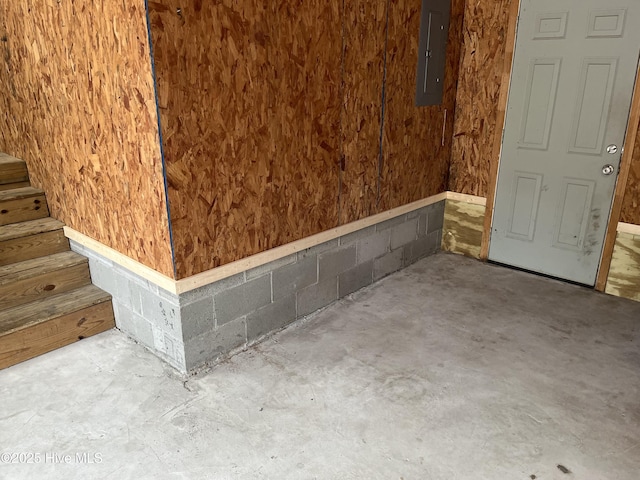 room details featuring electric panel and concrete block wall