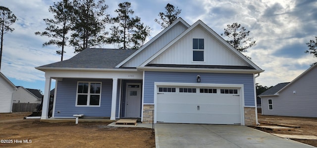 view of front of house with board and batten siding, concrete driveway, and a shingled roof