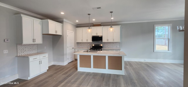 kitchen featuring white cabinetry, a center island with sink, visible vents, and stainless steel appliances